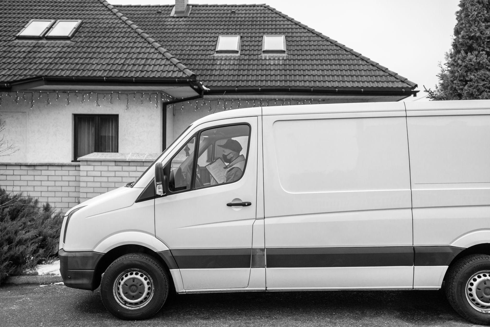 A Dubé Plumbing service van parked outside a suburban home